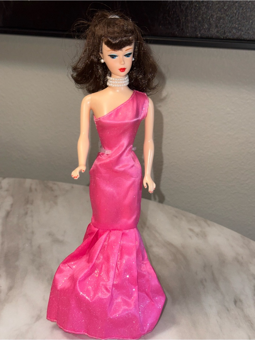 Barbie 50th celebration doll wearing pearls and pink one strap dress